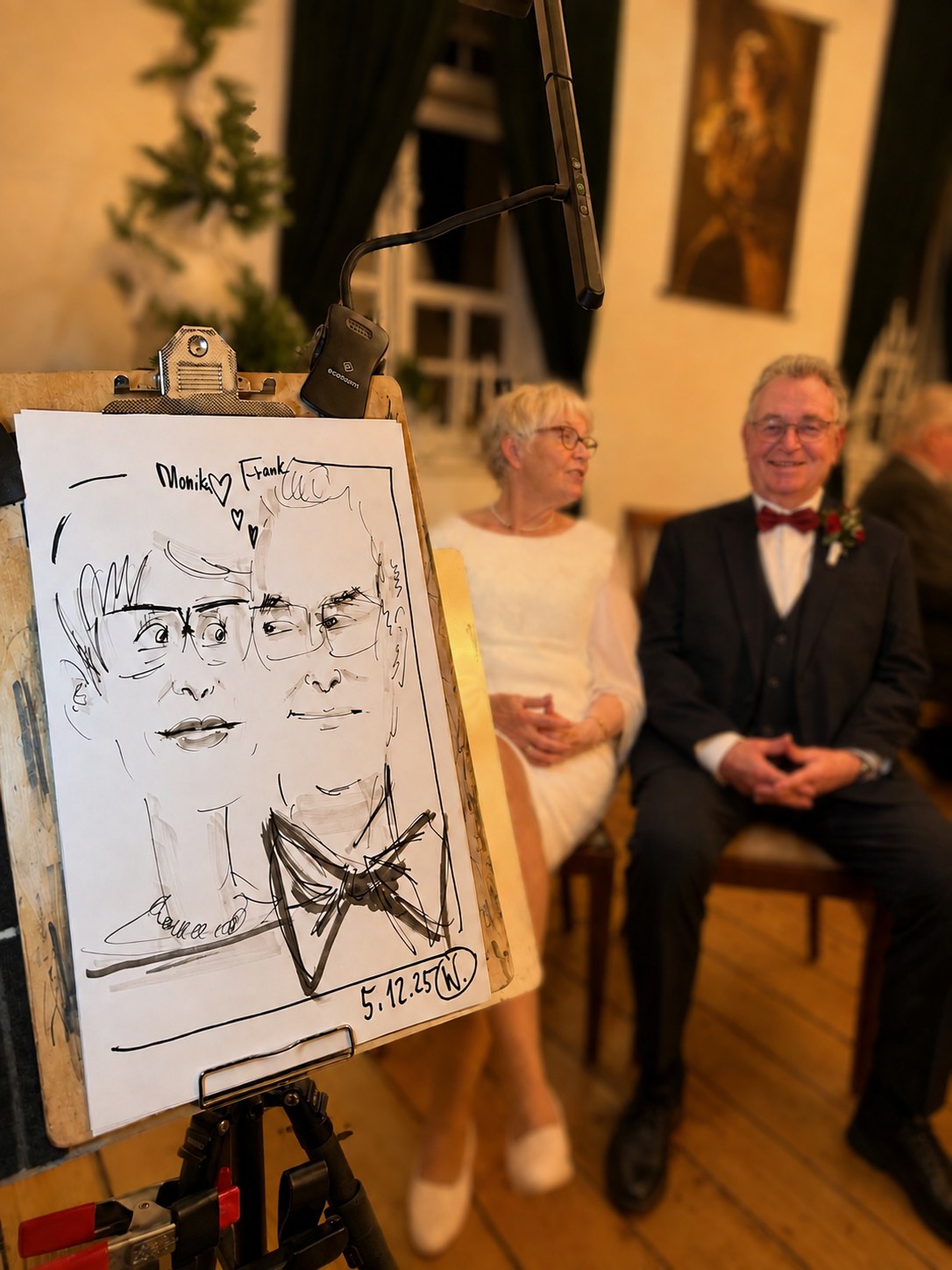 Älteres Brautpaar sitzt neben seiner live gezeichneten Karikatur