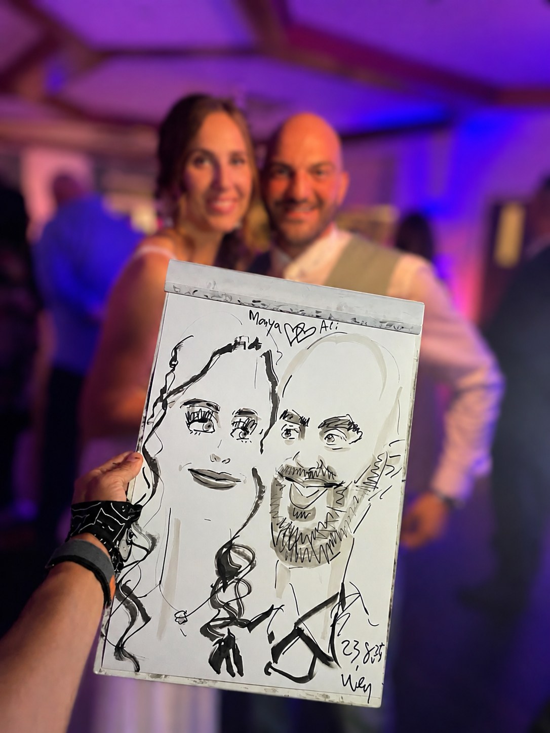 Brautpaar präsentiert seine live gezeichnete Karikatur, Frau links und Mann rechts