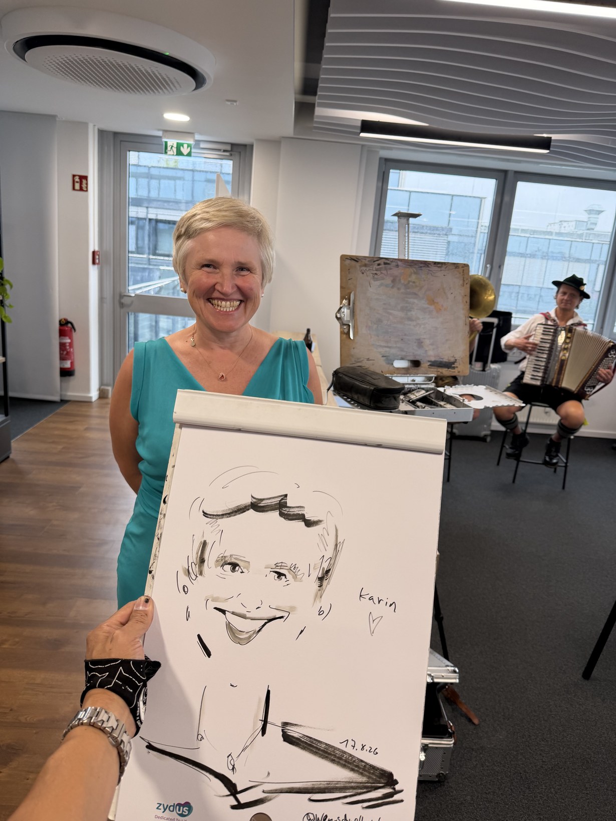 Frau im grünen Kleid hält ihre gezeichnete Karikatur