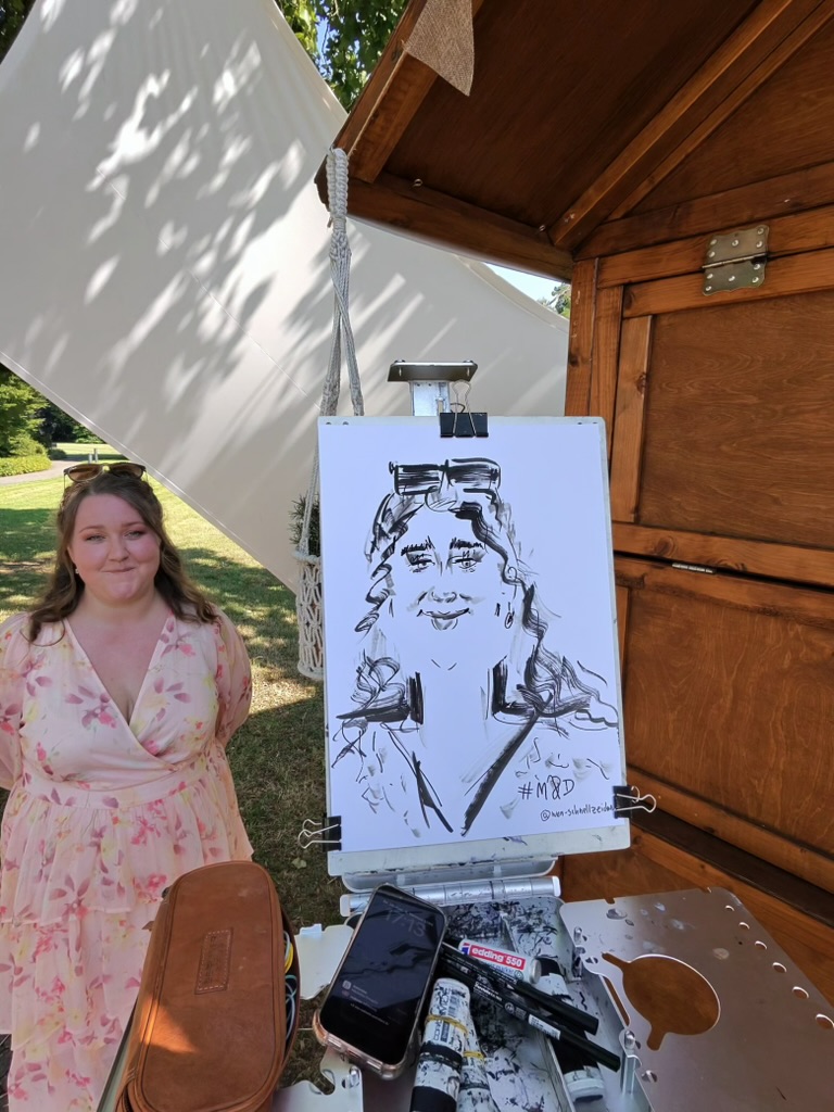 Frau steht neben ihrer live gezeichneten Karikatur bei einer Feier im Freien