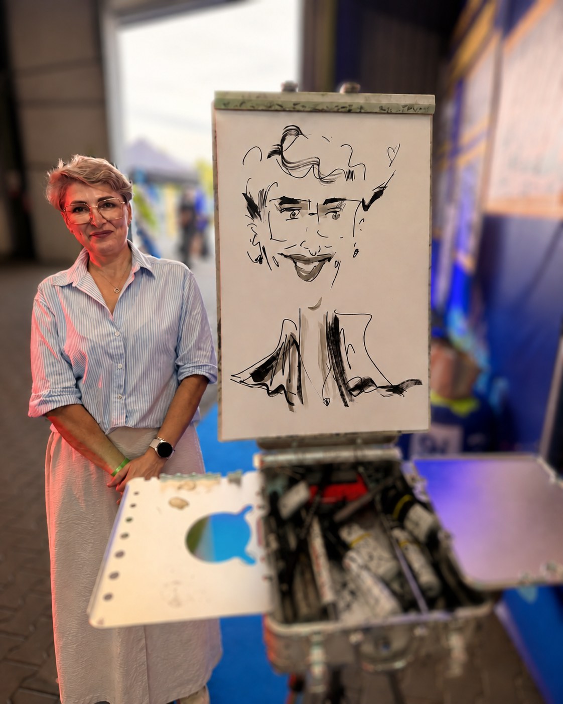 Frau steht neben ihrer gezeichneten Karikatur bei einer Veranstaltung