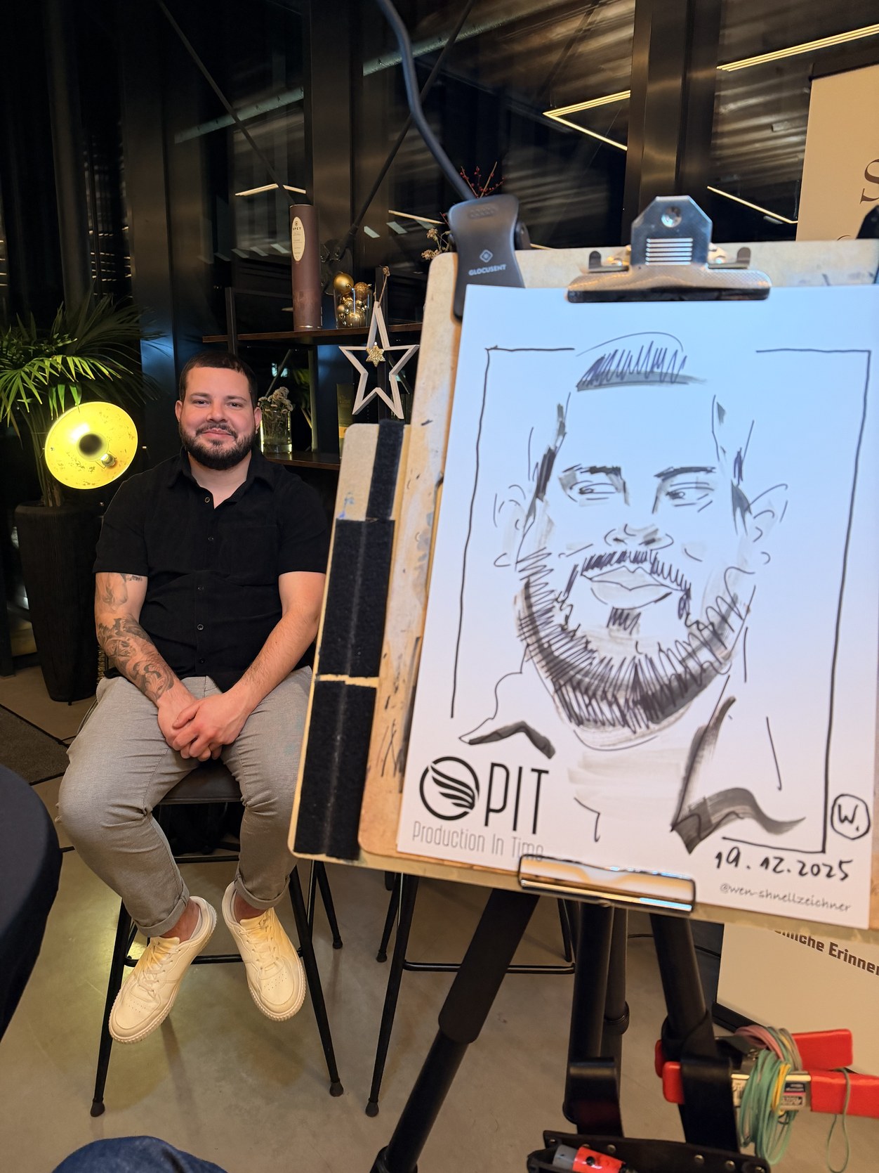 Mann sitzt neben seiner gezeichneten Karikatur