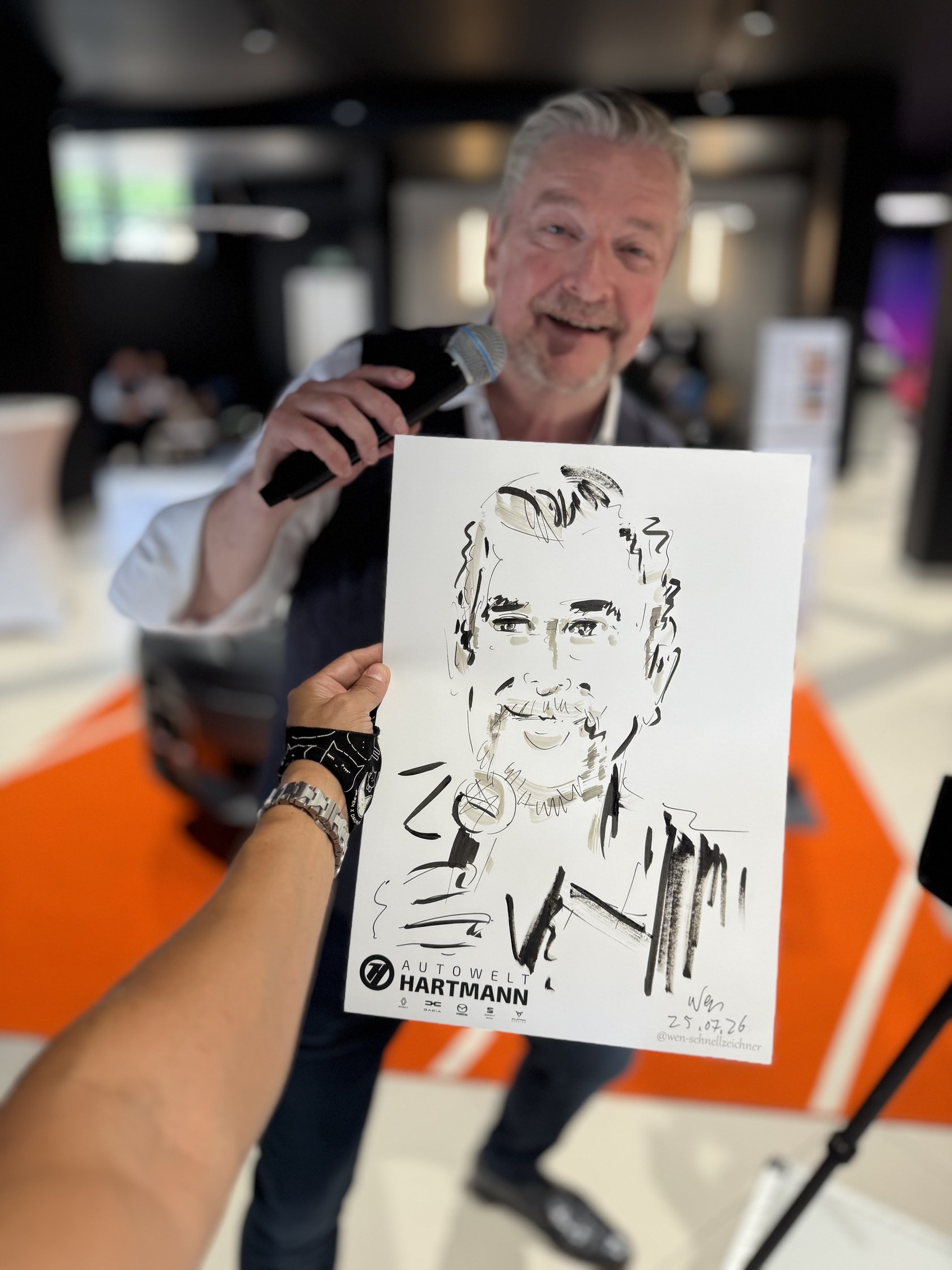 Mann mit Mikrofon hält seine gezeichnete Karikatur