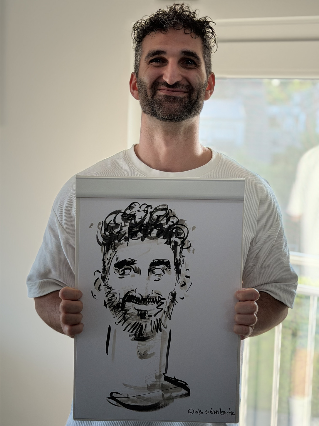 Mann präsentiert seine live gezeichnete Karikatur bei einer Geburtstagsfeier