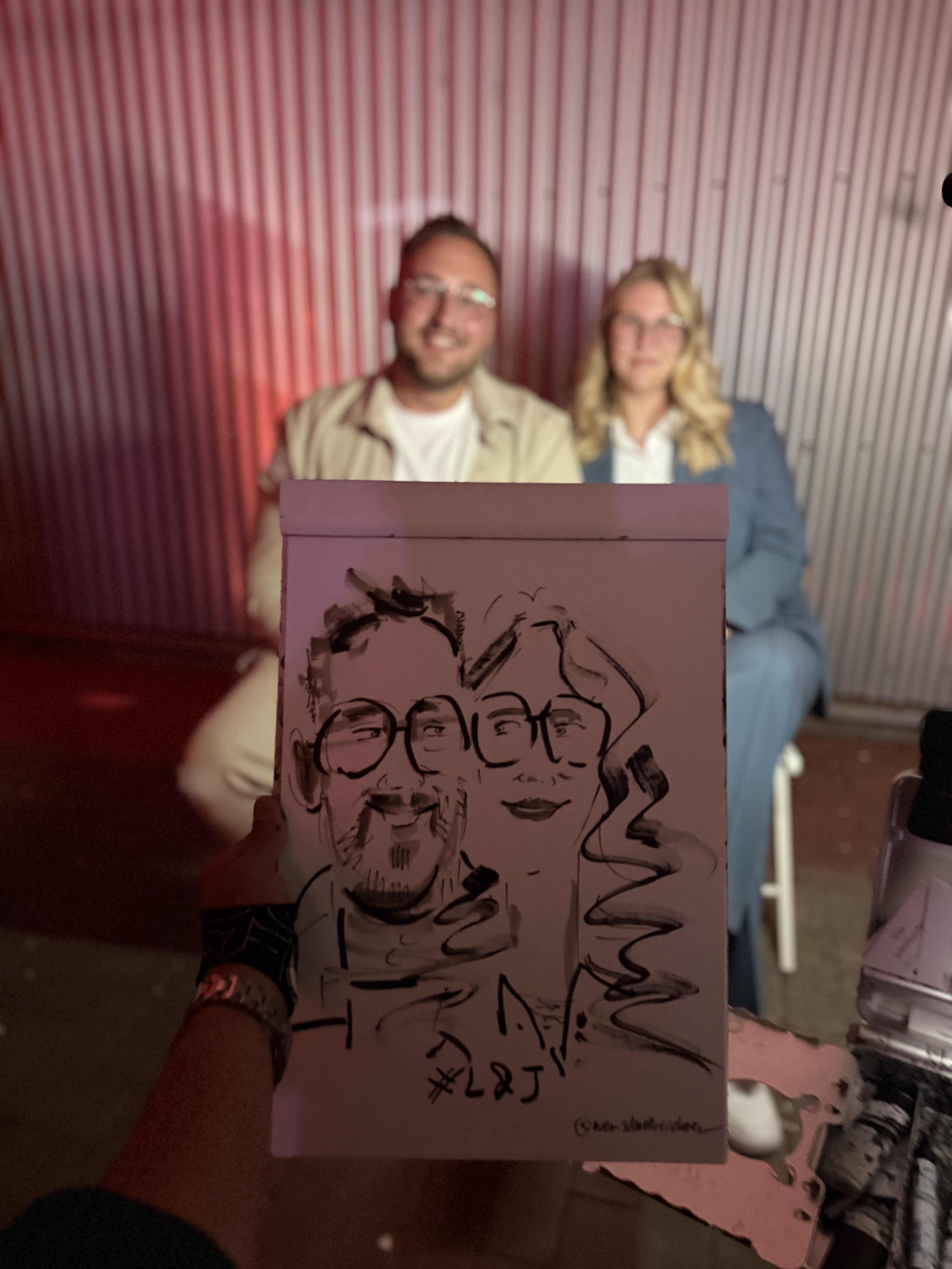 Paar mit seiner live gezeichneten Karikatur bei einer Feier