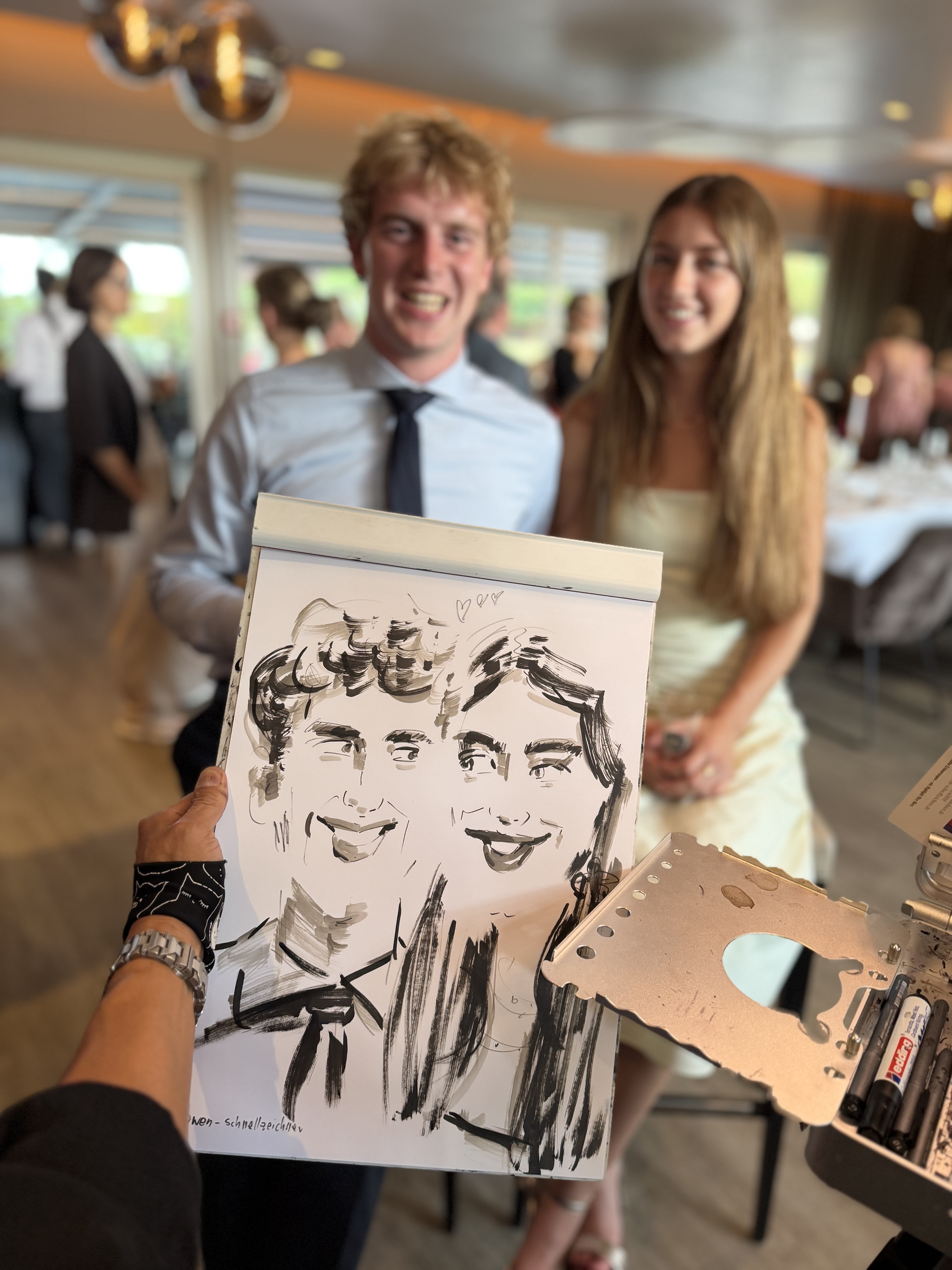 Junges Paar mit seiner live gezeichneten Karikatur bei einer Veranstaltung