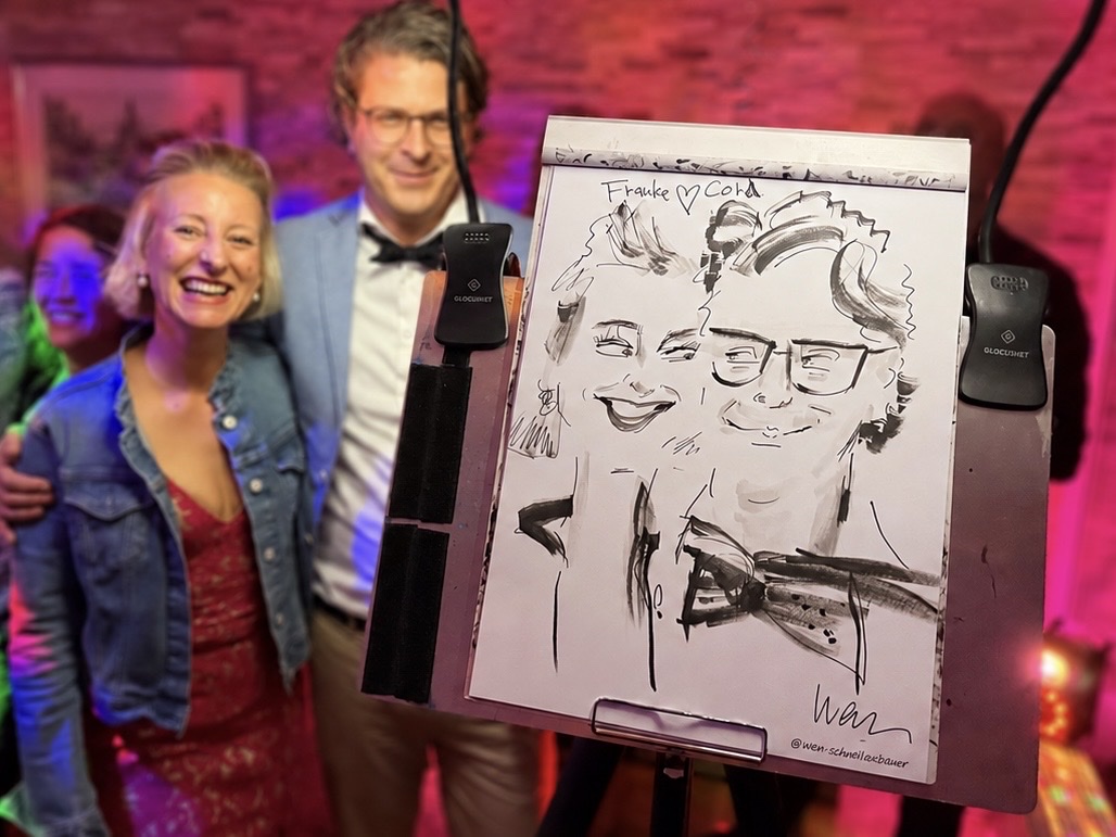 Paar mit seiner live gezeichneten Karikatur bei einer Veranstaltung