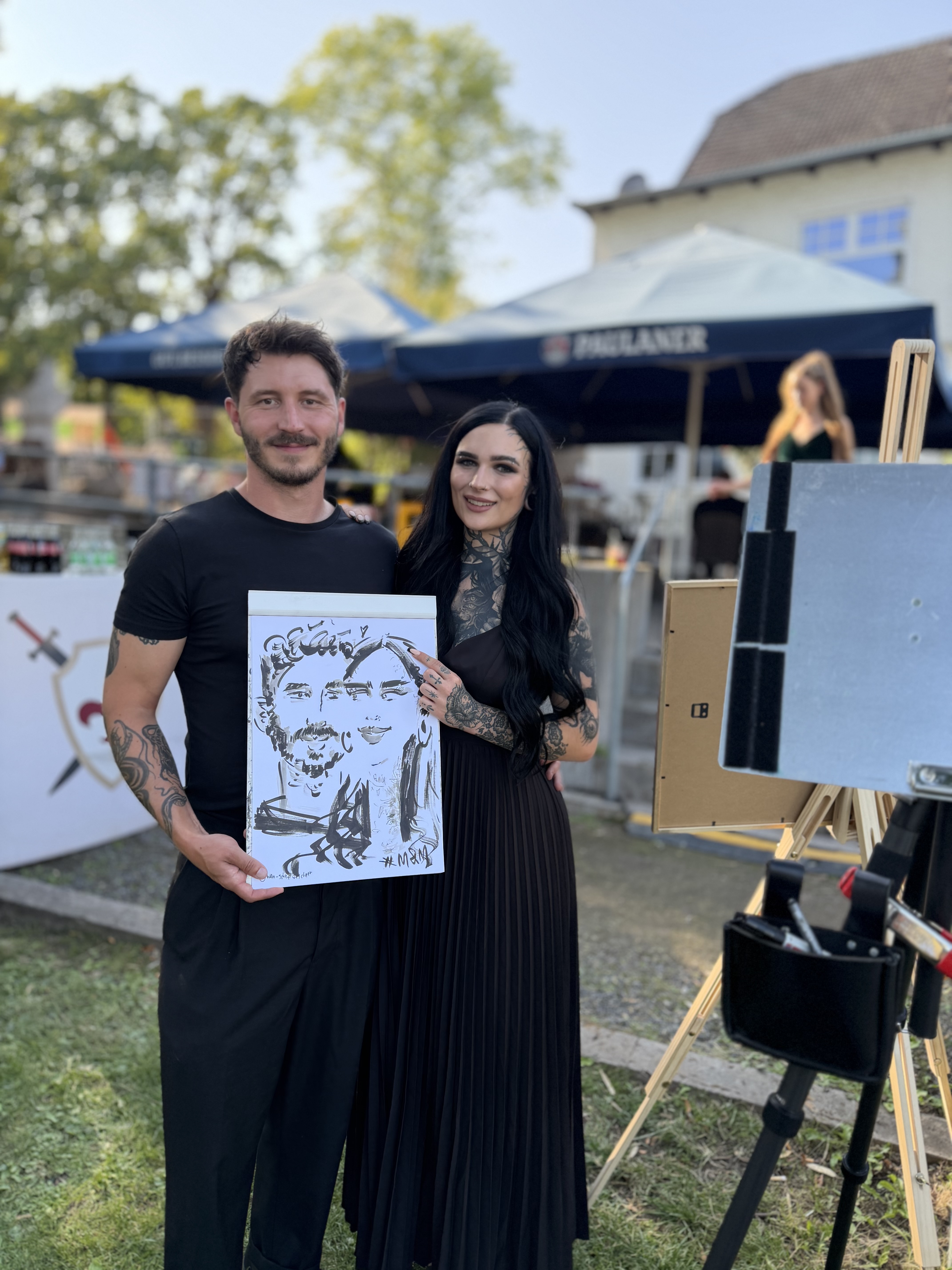 Paar präsentiert seine live gezeichnete Karikatur bei einer Feier im Freien