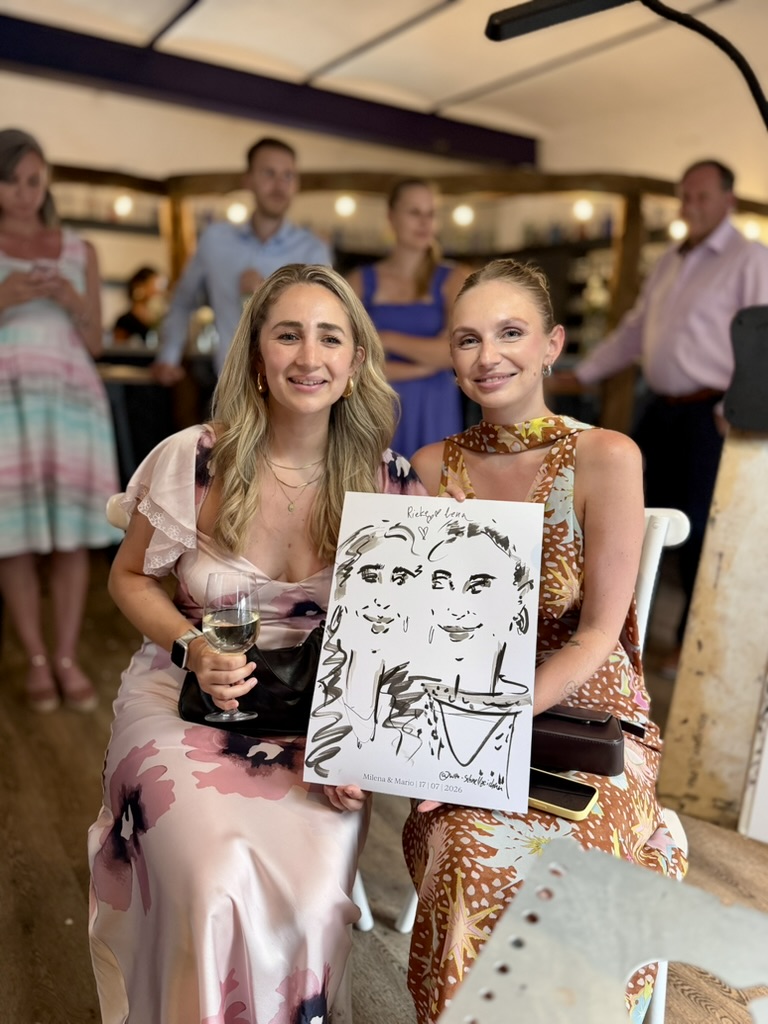 Zwei Frauen präsentieren ihre live gezeichnete Karikatur bei einer Veranstaltung